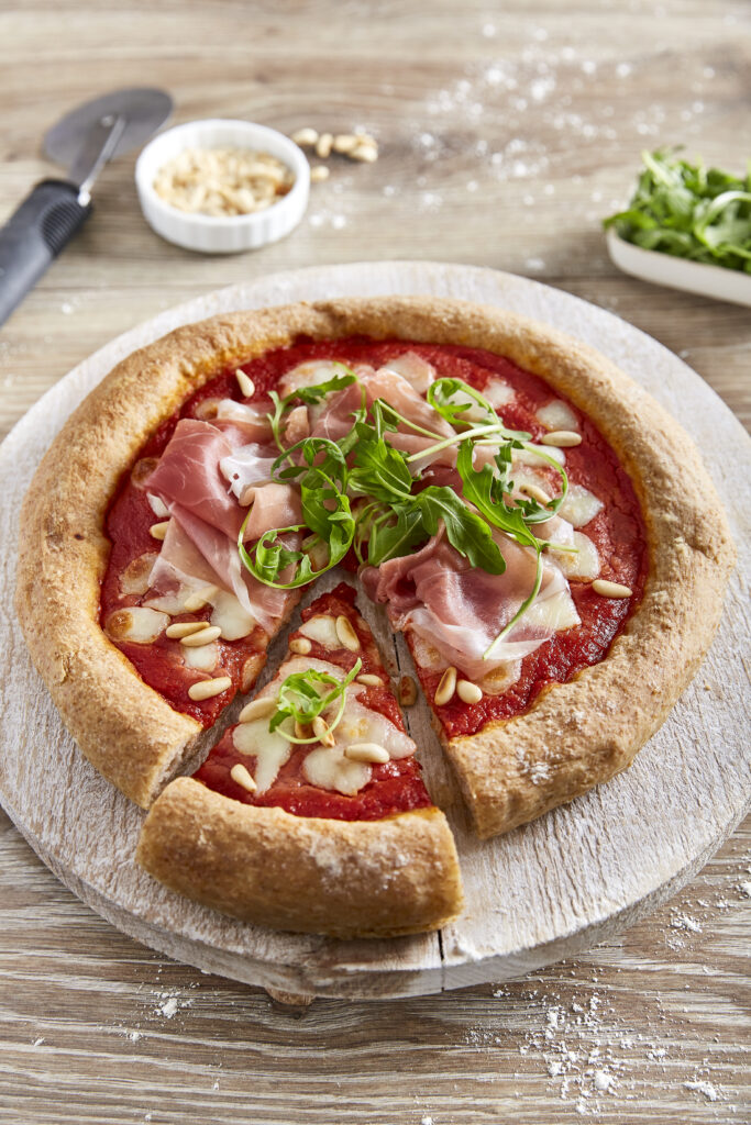 Whole wheat pizza with parma ham and rucola