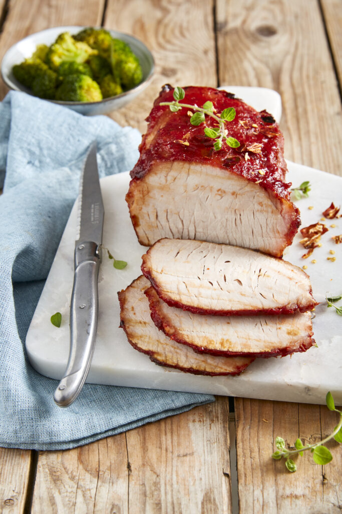 Pork loin roast in oven with tomato, honey and chili