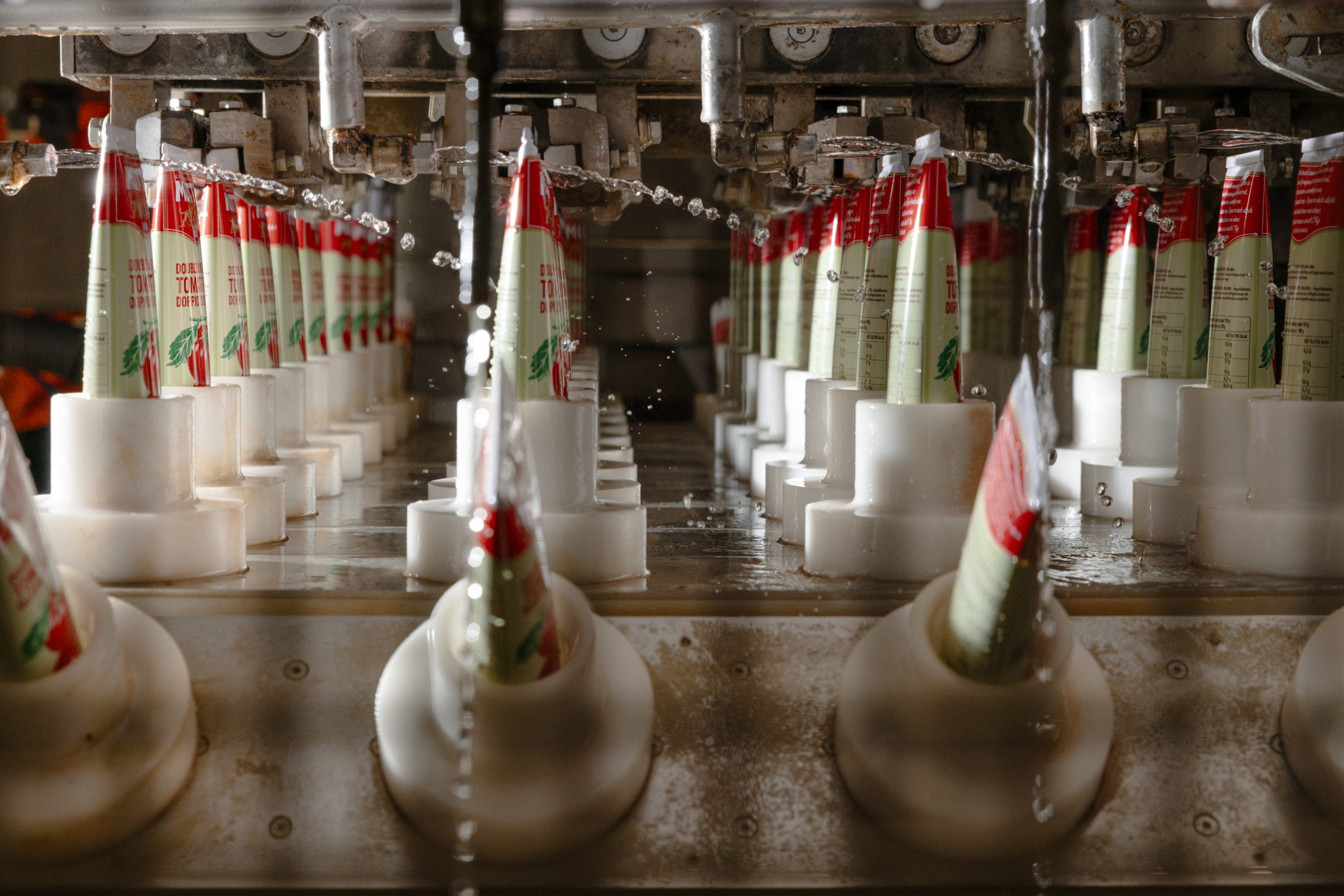 Tubes of tomato paste being capped on the filling line