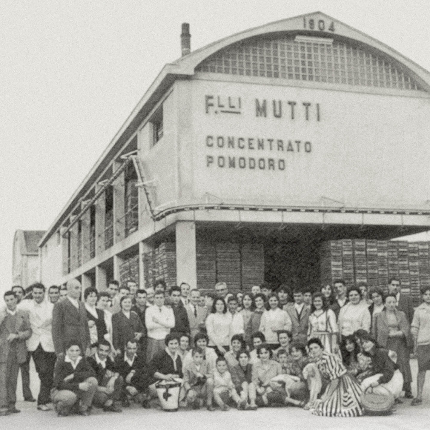 Vintage photo of the F.lli Mutti factory facade with workers gathered outside