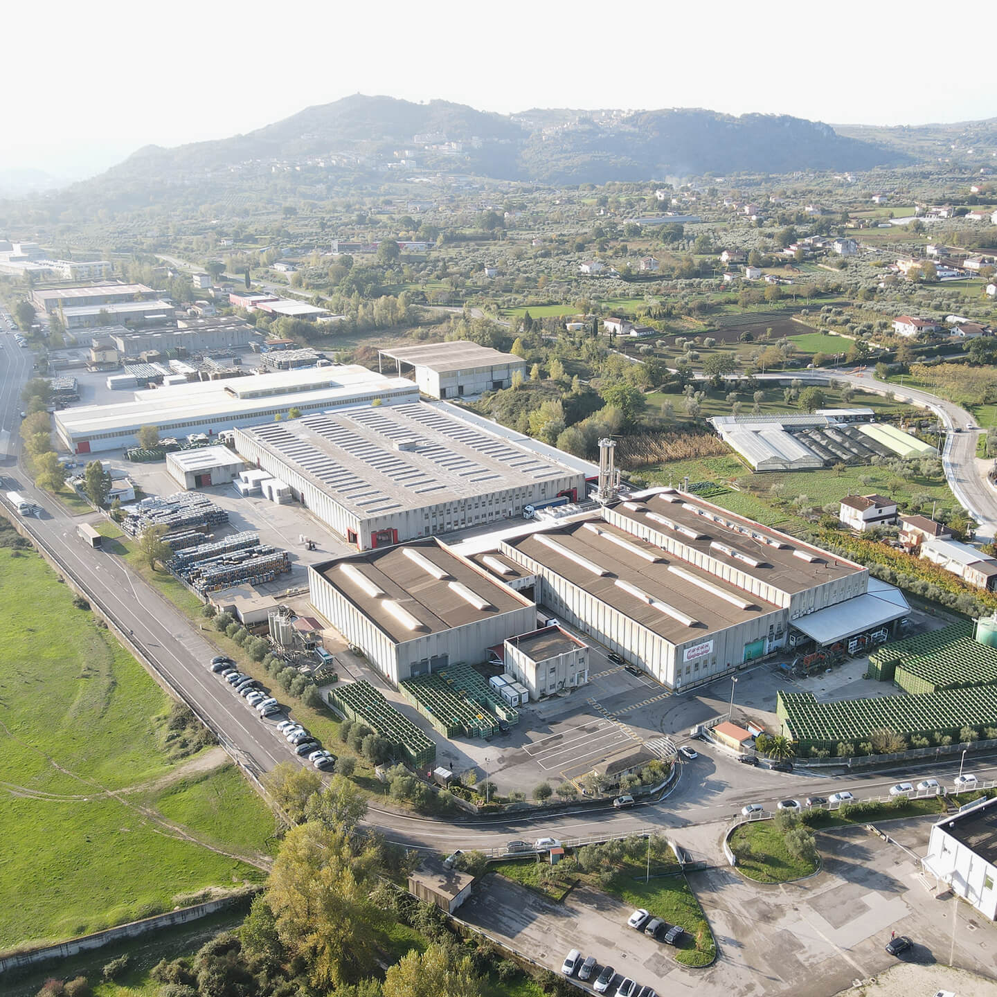 Aerial view of the Mutti Fiordagosto factory complex amid green hills
