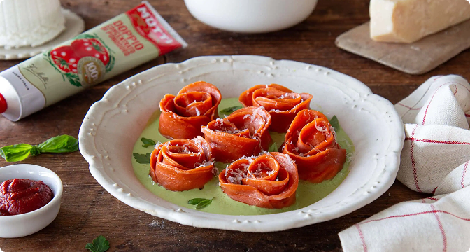 Rolled pizza roses on a plate with Mutti tomato paste tube and basil