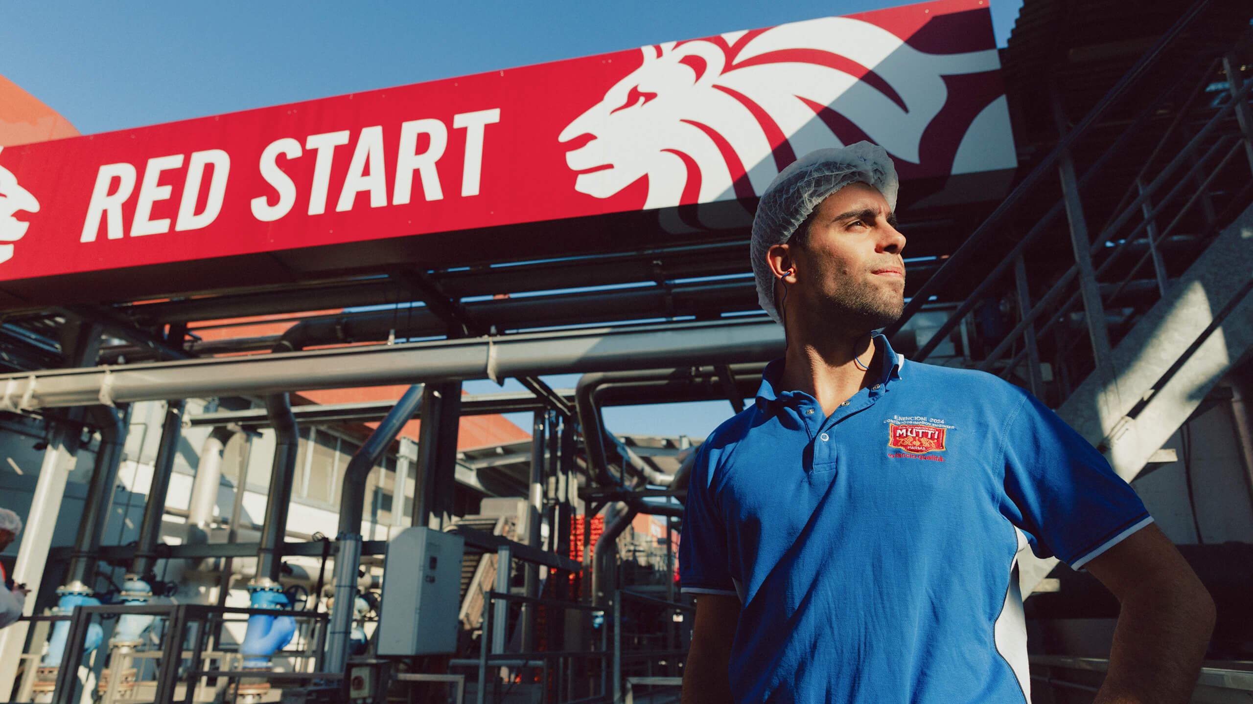 Mutti factory worker standing beneath a Red Start banner