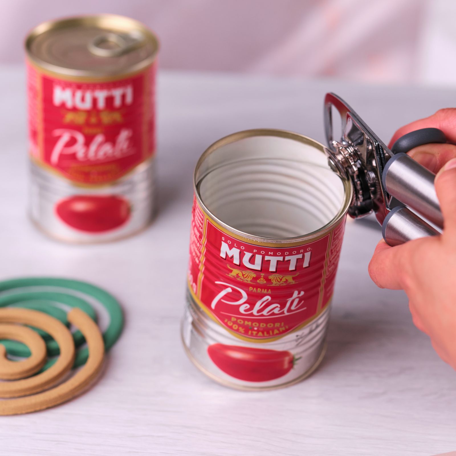 Opening a Mutti Pelati tin next to wooden mosquito coil holders