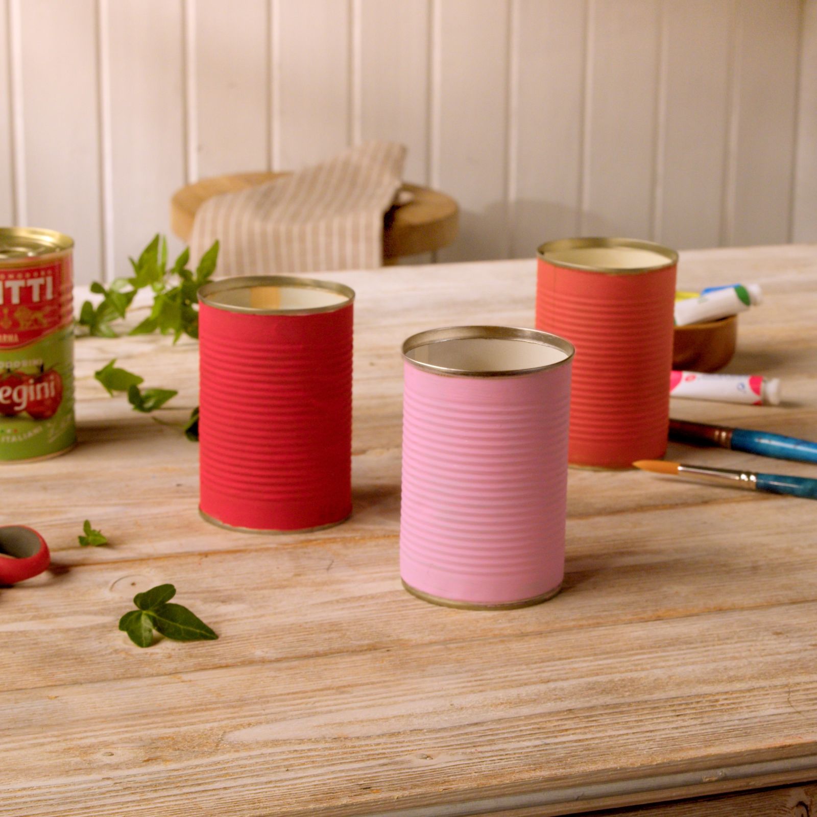 Three painted tin cans and paintbrushes for a rain saver craft