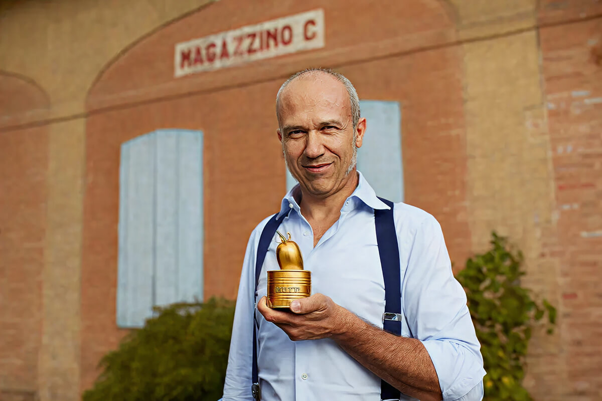 Man holding the golden Pomodorino d'Oro trophy outside Magazzino C