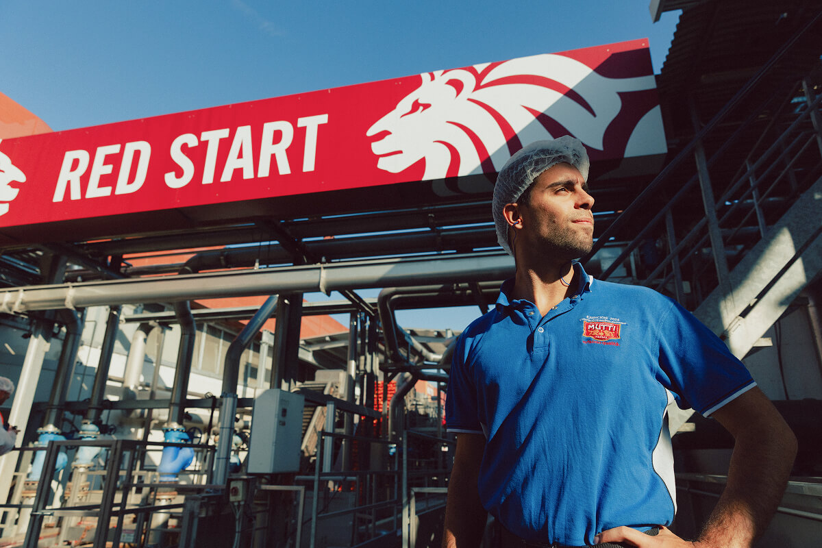 Mutti employee standing beneath the Red Start sign at the factory