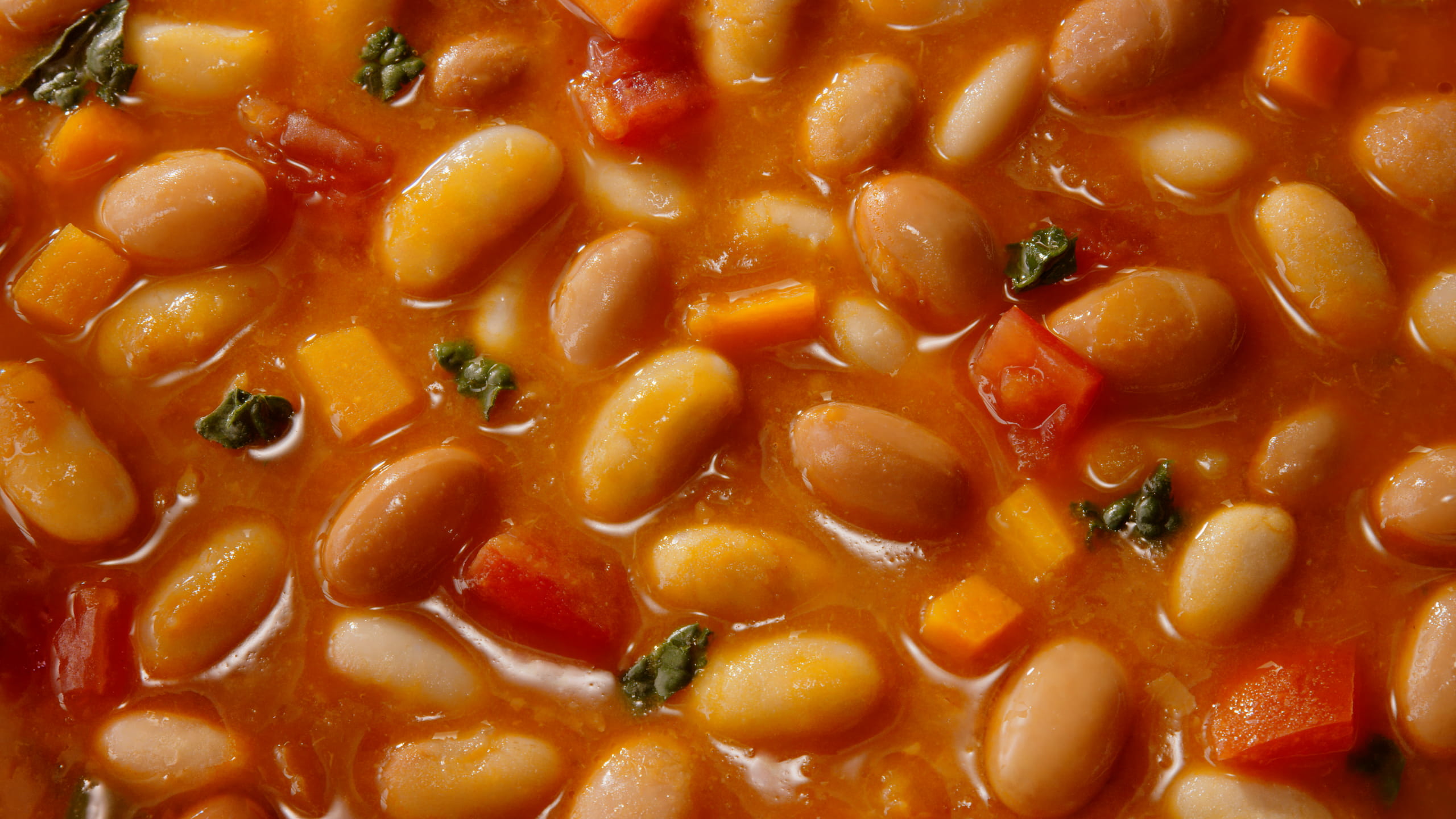 Close-up of Mutti bean and vegetable soup with diced carrots