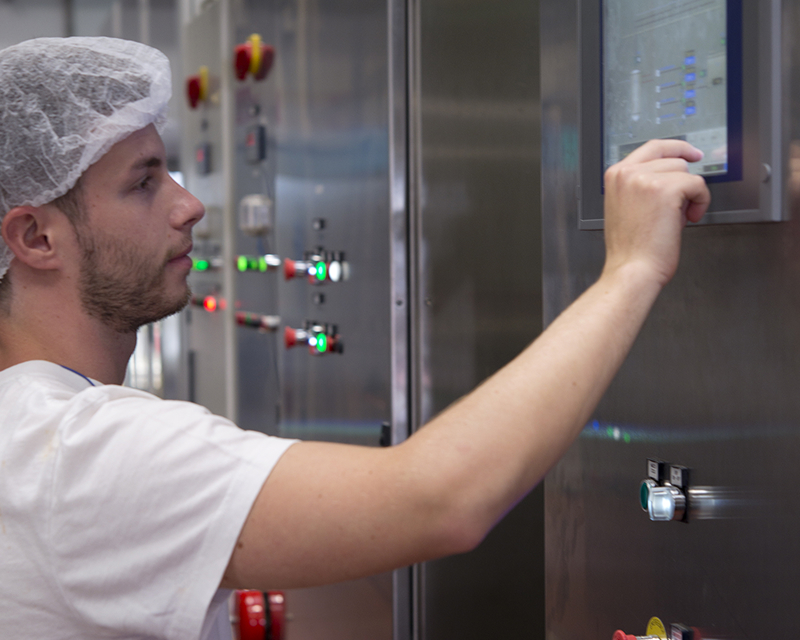 Mutti factory worker adjusting settings on a production control panel