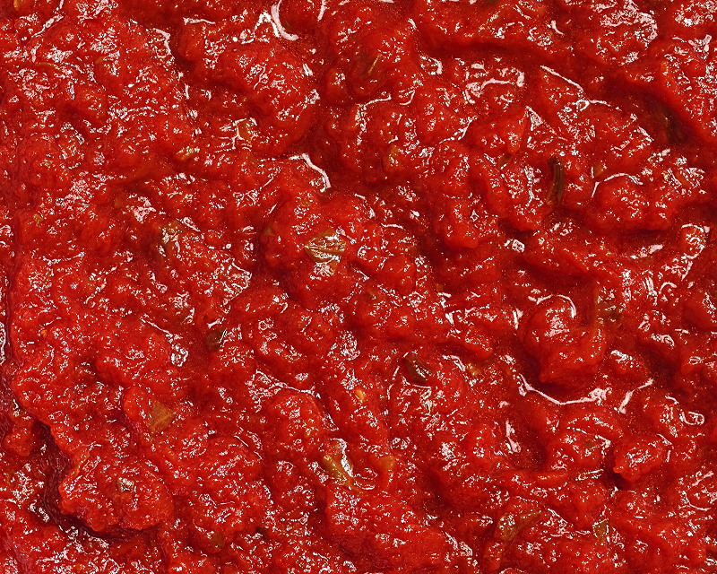 Close-up texture of chunky tomato pasta sauce with herbs