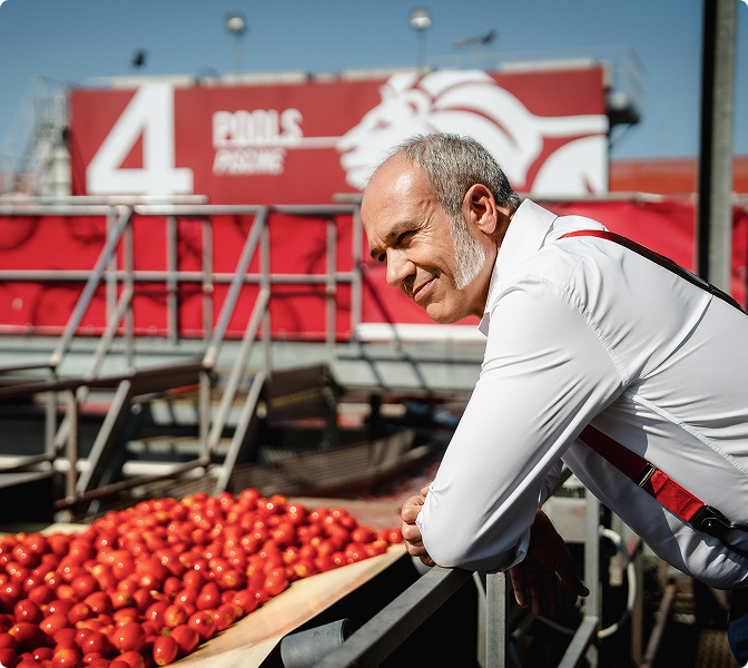 Man leaning on a railing beside a Mutti tomato-washing pool