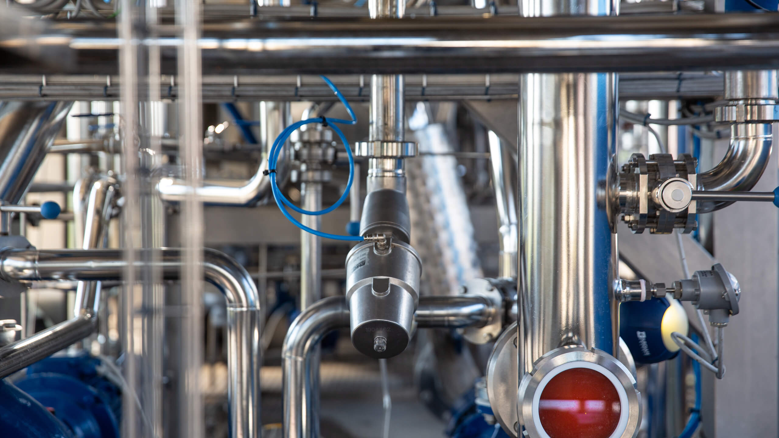 Close-up of stainless steel pipes and valves in the factory