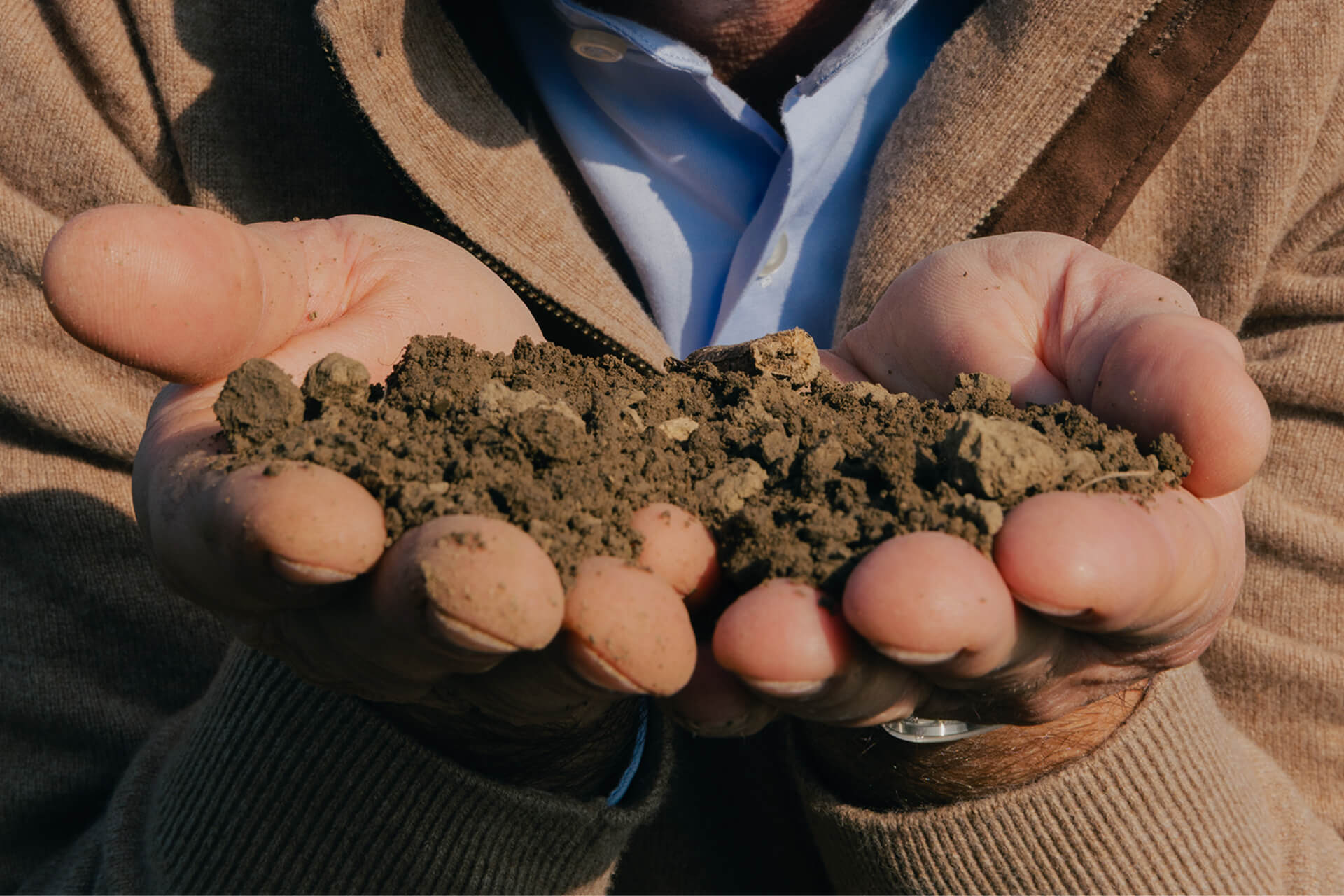 Farmer holding a handful of soil in cupped hands