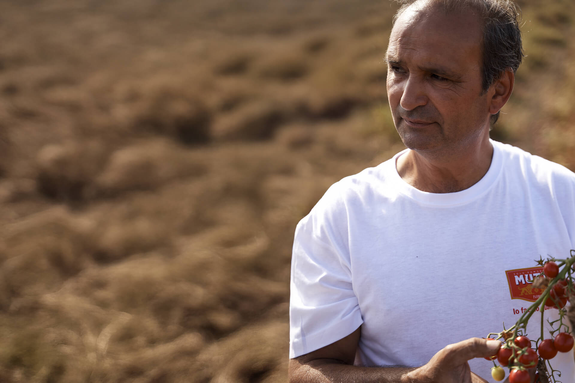 Farmer in a Mutti T-shirt standing in a harvested field