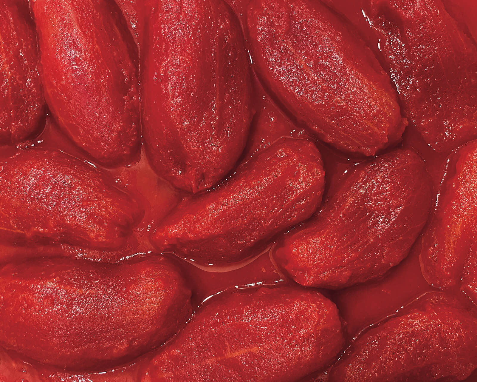 Close-up of whole peeled tomatoes packed in tomato juice