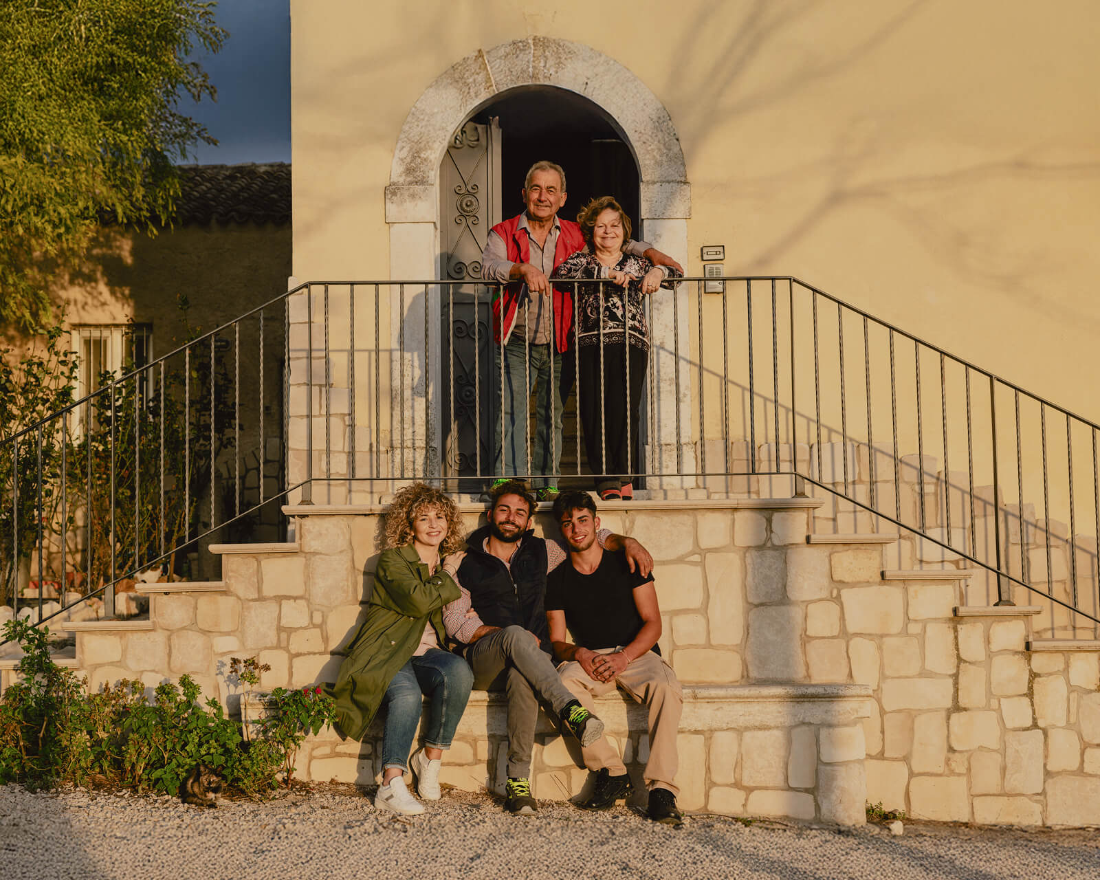 Farming family of five posing together on a stone staircase