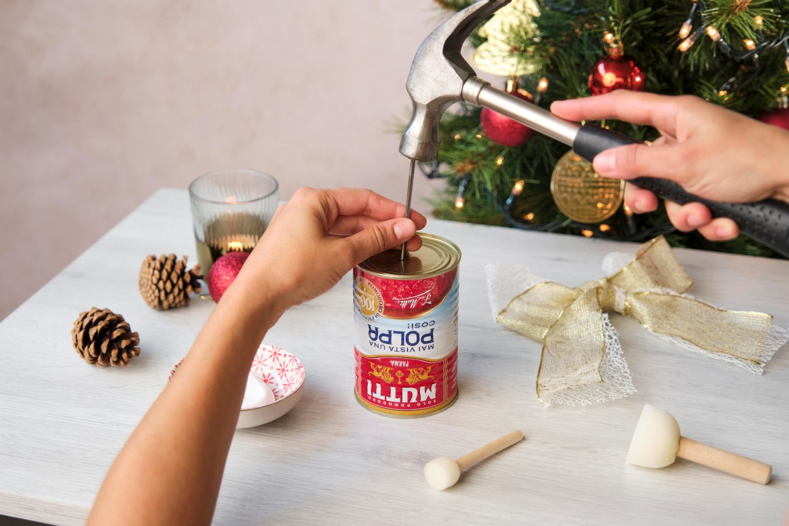 Hammering a nail into the top of a Mutti Polpa tin