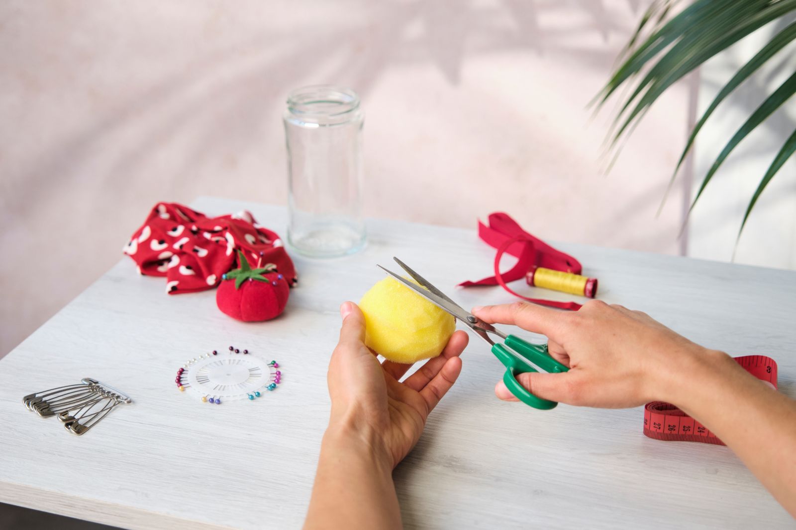 Shaping a yellow sponge dome with scissors for a pincushion
