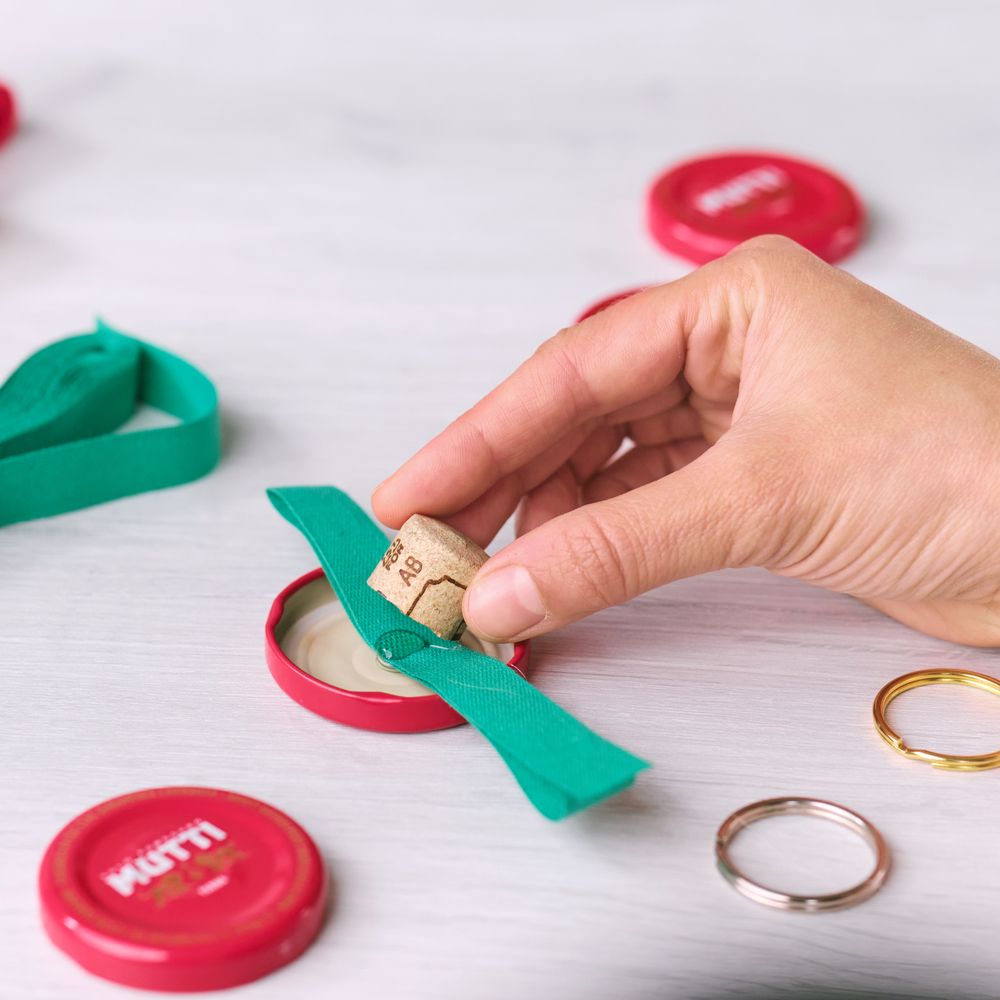 Inserting a ribbon-wrapped cork into a Mutti bottle cap