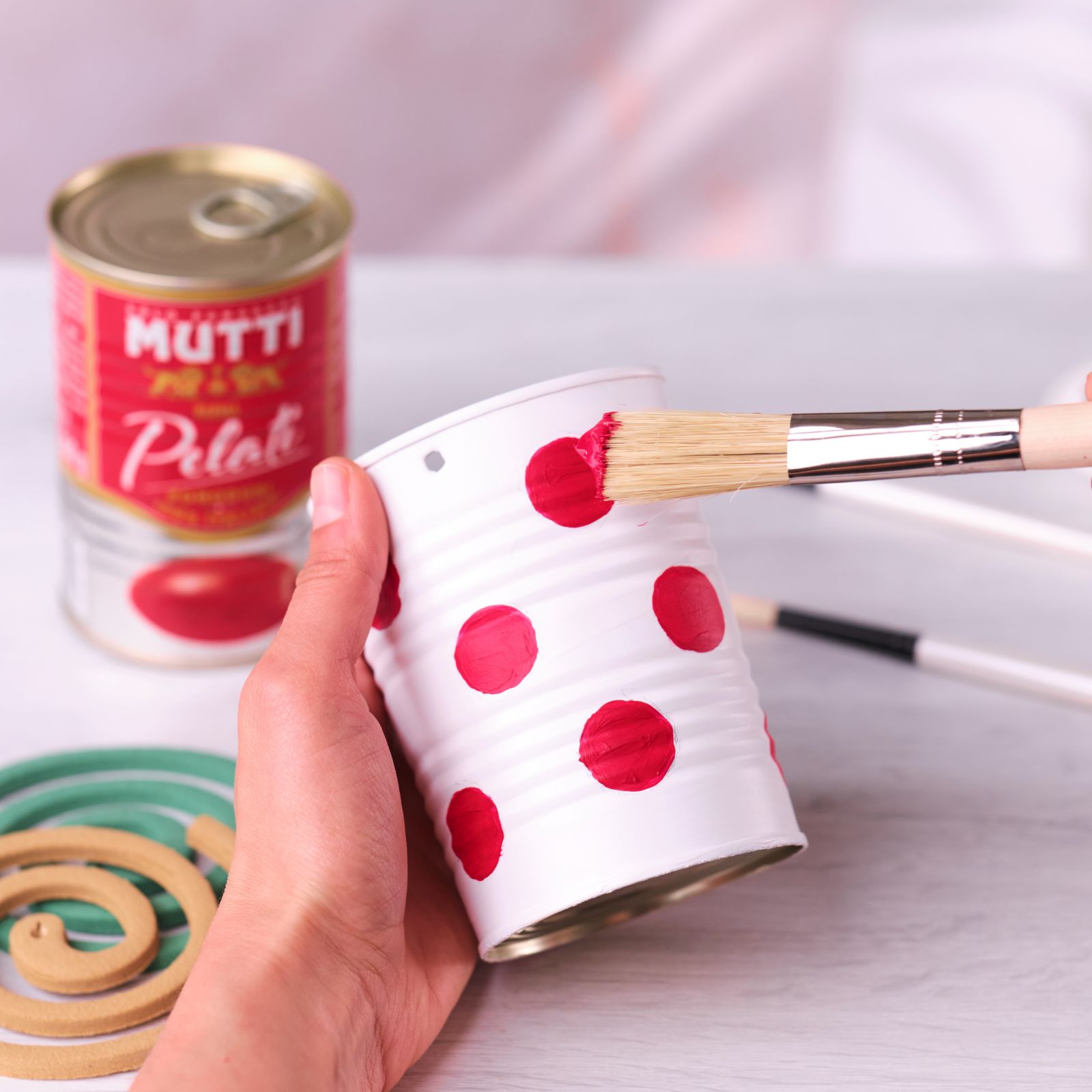Painting red dots onto a white-painted tin can