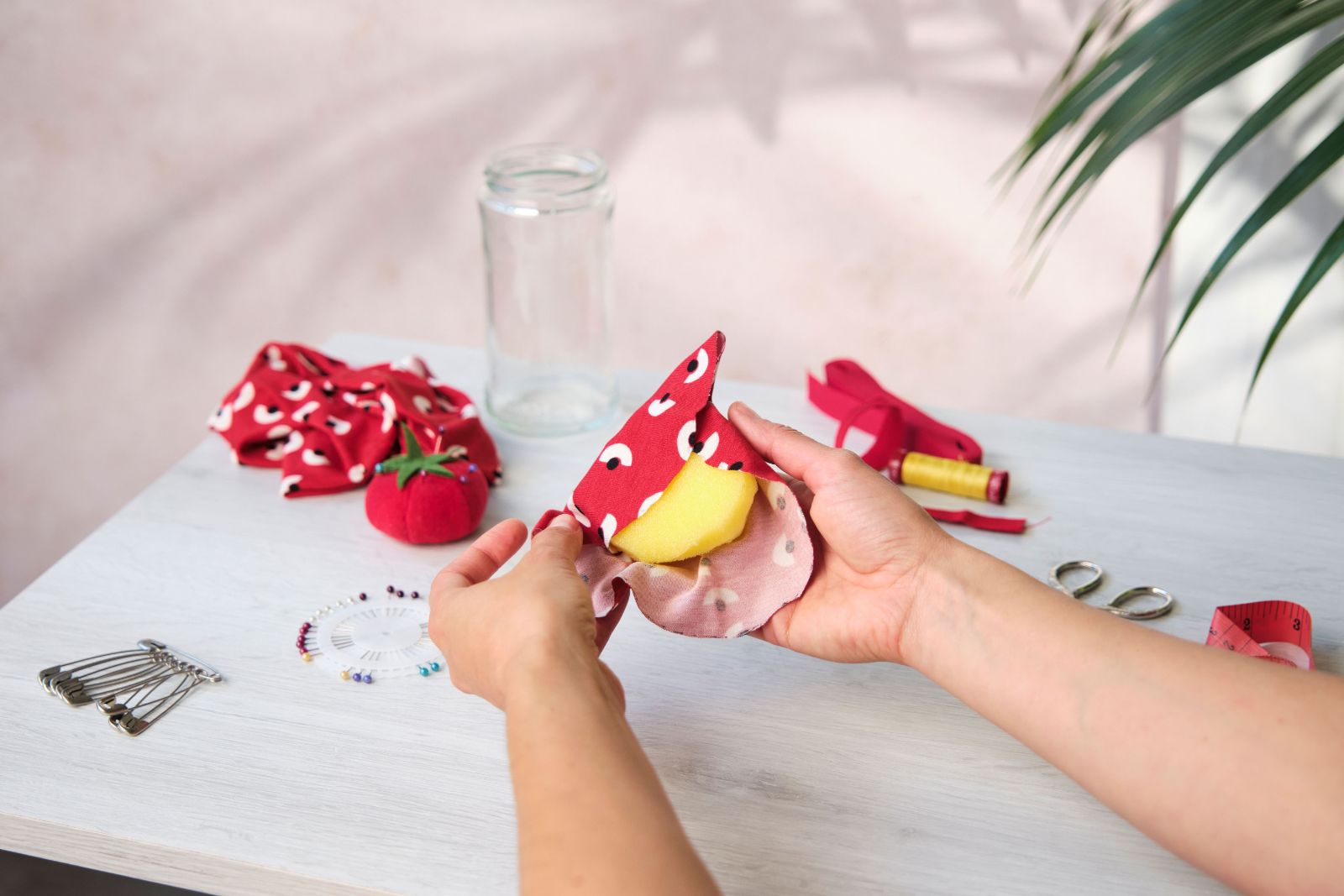 Wrapping red patterned fabric around a sponge dome for a pincushion