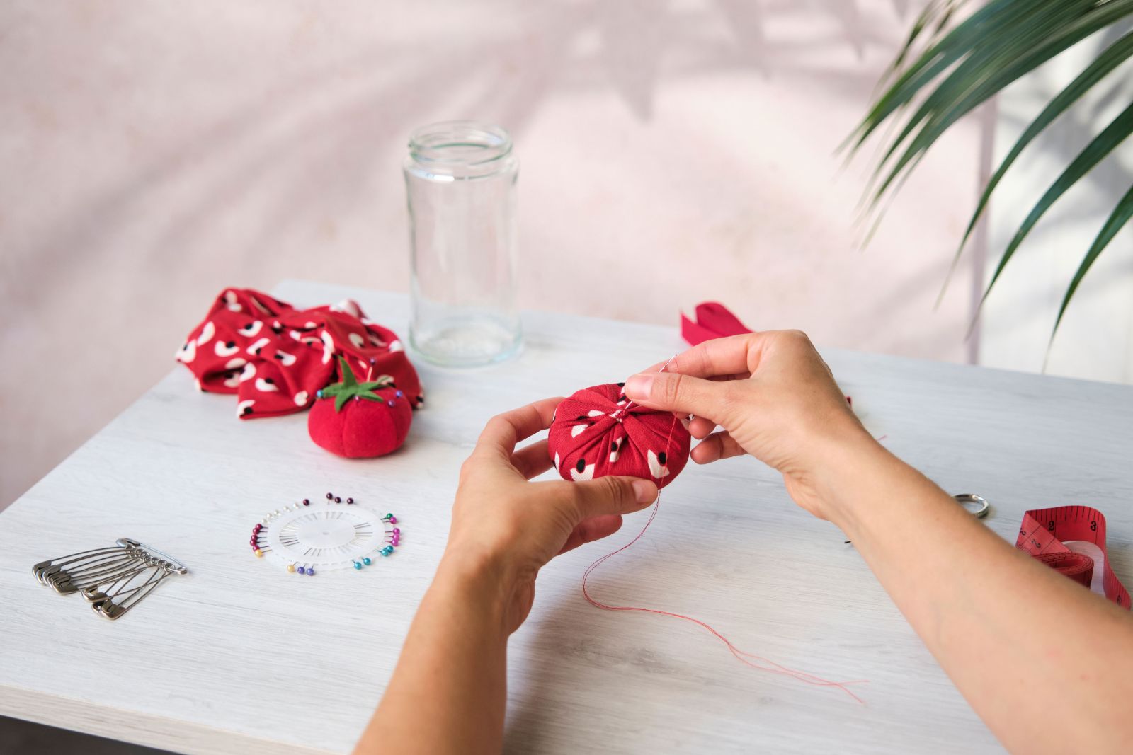 Stitching red fabric closed at the back of a sponge dome