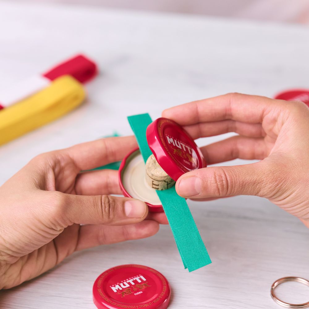 Joining two Mutti bottle caps together with ribbon and a cork