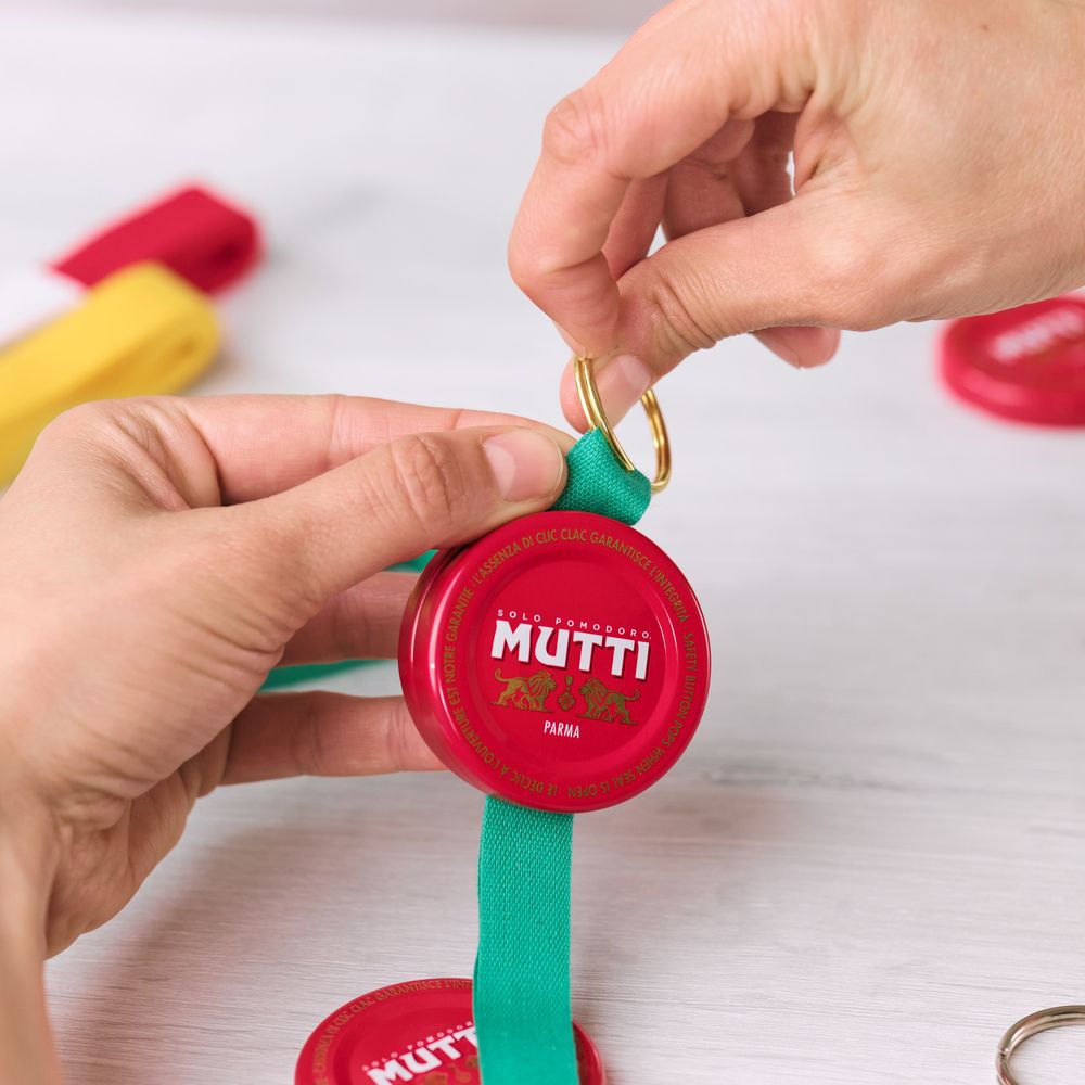 Threading a key ring through a Mutti bottle cap keychain