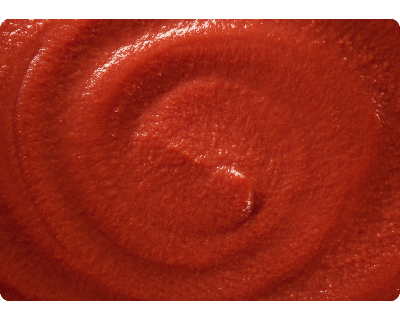 Smooth red tomato purée swirled in close-up