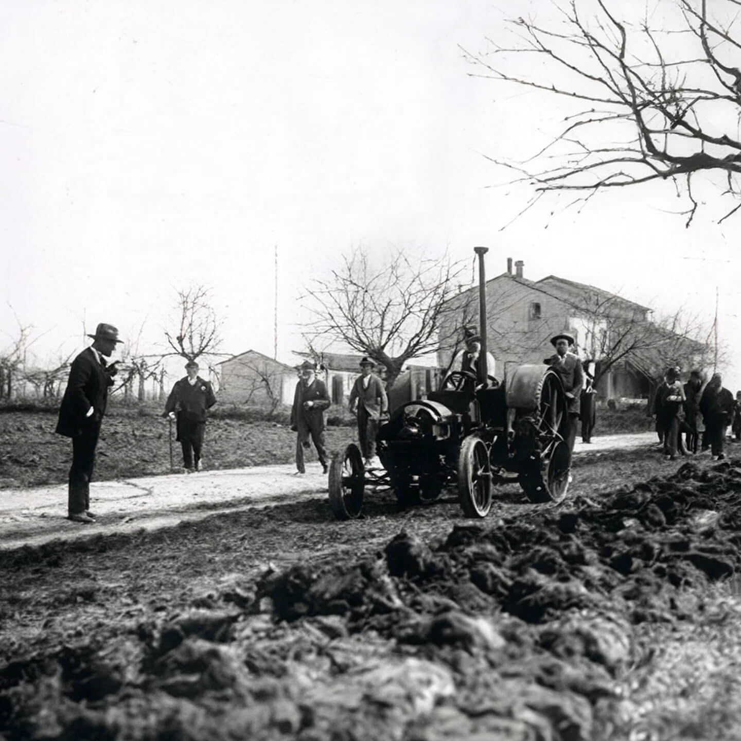 Vintage photo of an early steam-powered plough working a muddy field