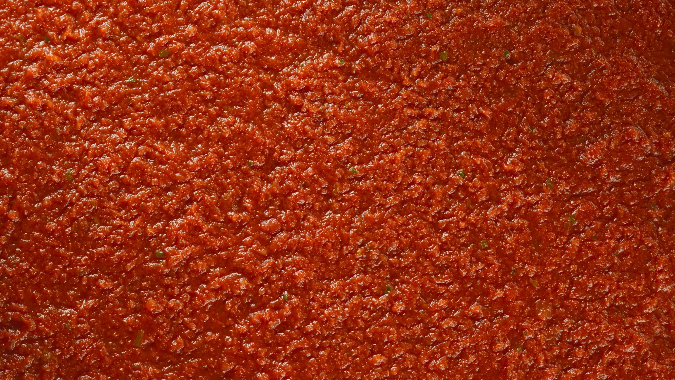 Close-up texture of Mutti pasta sauce with basil flecks