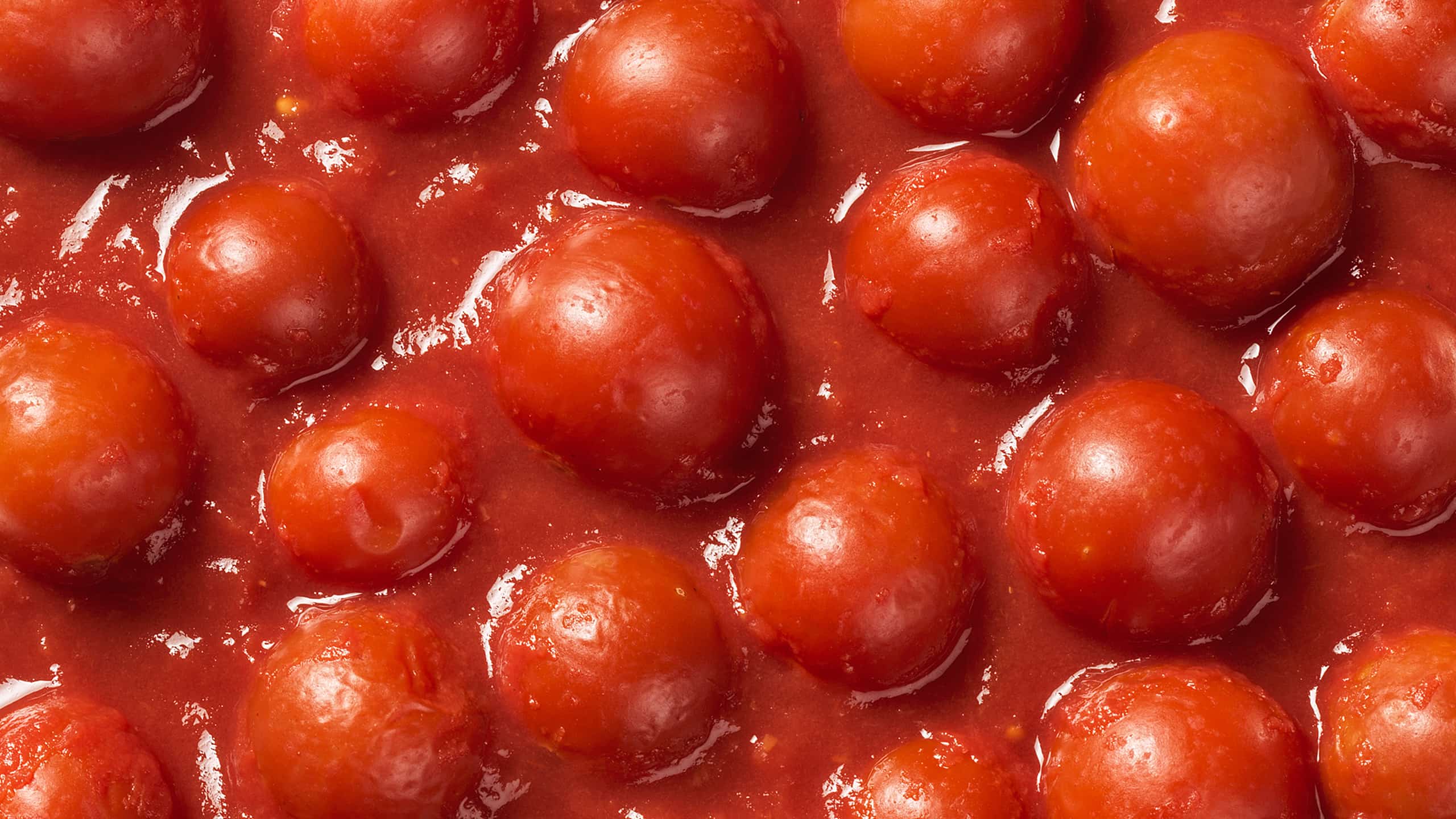 Close-up of whole cherry tomatoes in Mutti tomato sauce