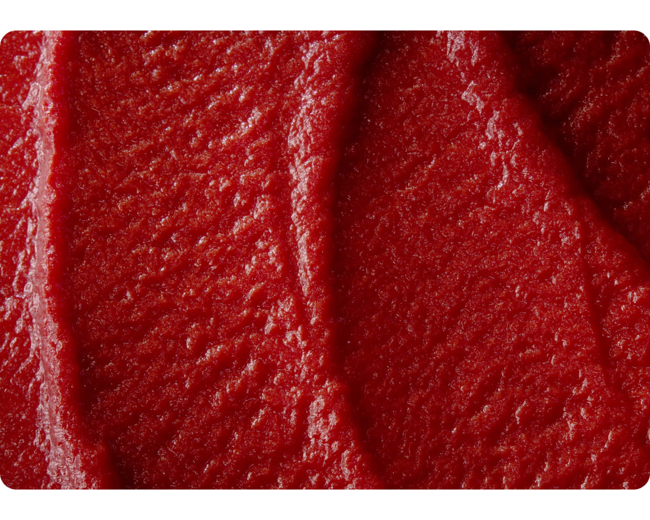 Glossy ridges of thick double concentrated tomato paste