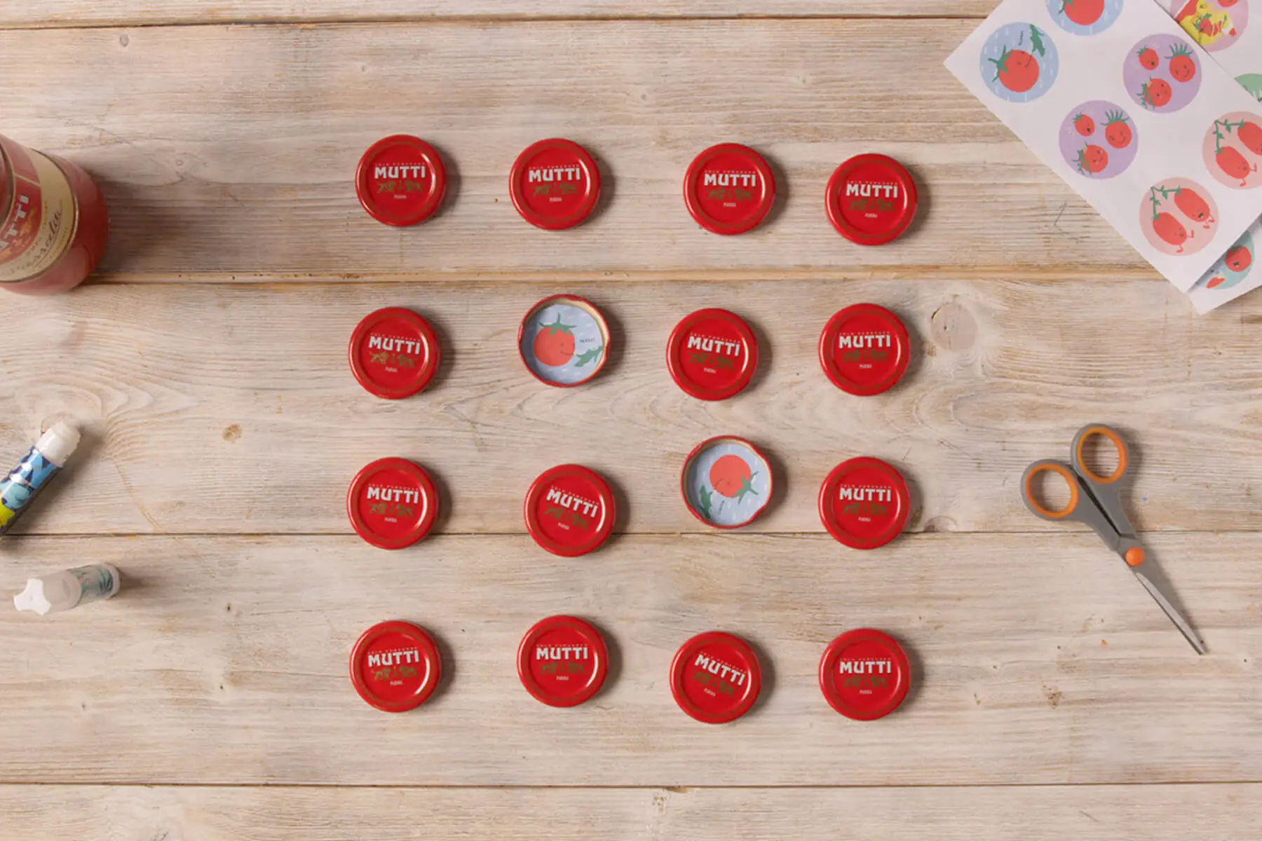 Mutti bottle caps and craft supplies laid out on a table