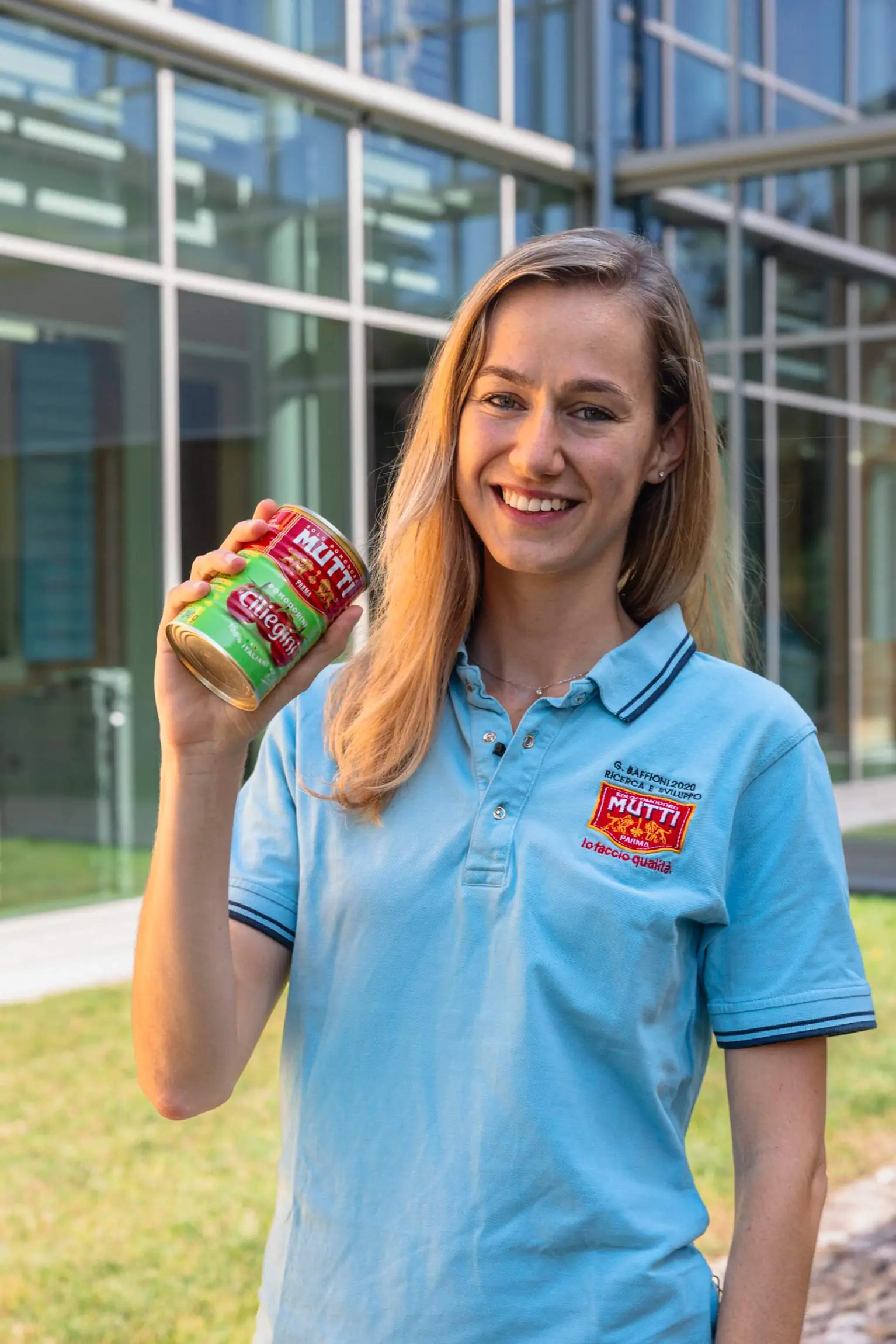 Mutti employee holding a jar of Mutti tomato puree, showcasing high-quality Italian tomato products.